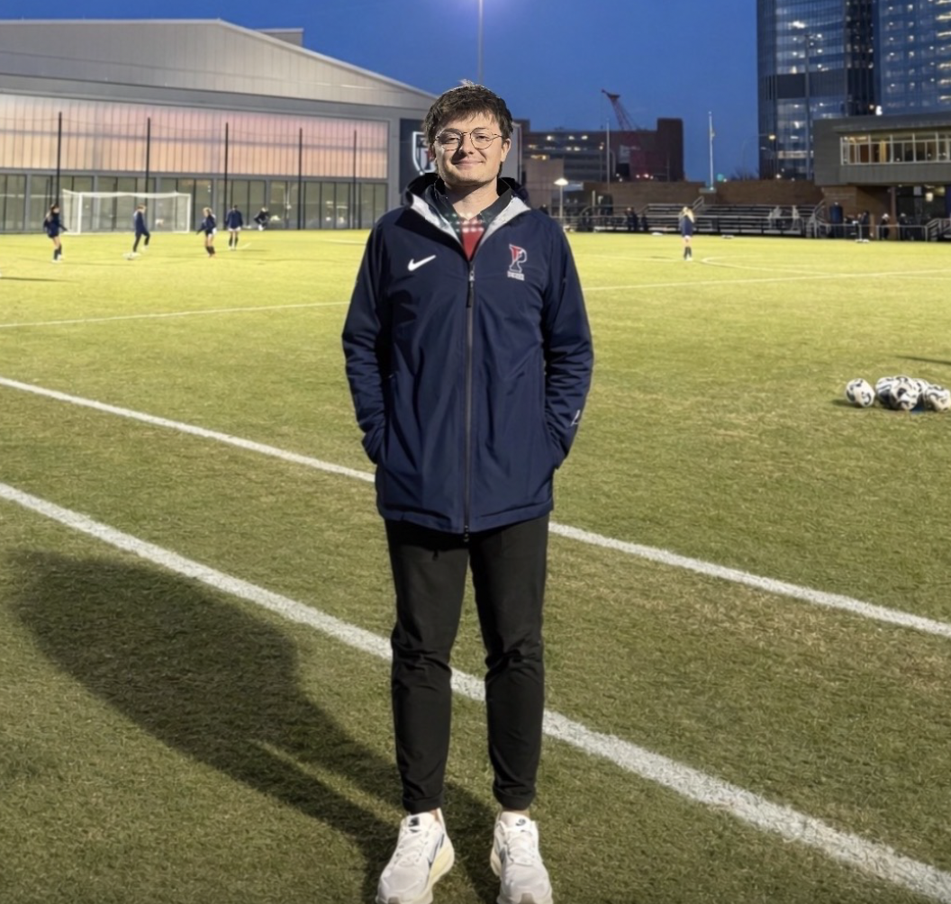 scholarship winner Hayden stands on a soccer field at night